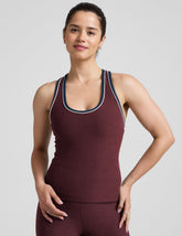 model wearing a maroon tank top with navy and white trim on a light gray background.